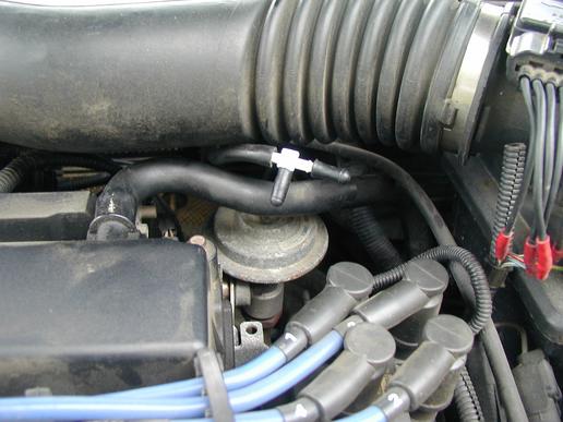 What are the symptoms of a carburetor vacuum line leak?